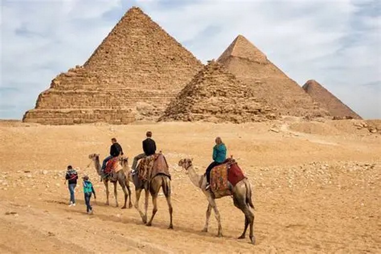 Du khách cưỡi lạc đà trước Kim Tự Tháp Giza lúc chiều
