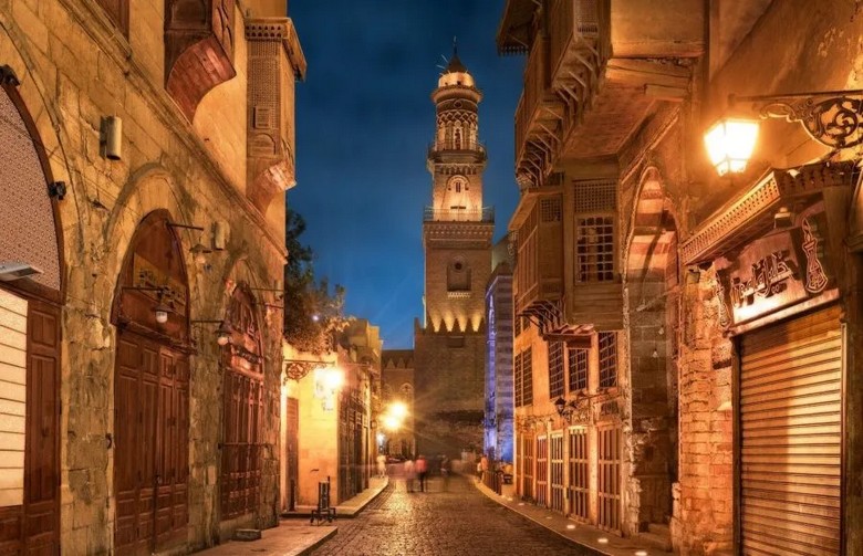 Con phố cổ Al-Muizz lát đá lên đèn về đêm với nhà thờ Hồi giáo hai bên