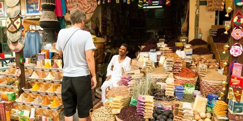  Du khách và người bán đang vui vẻ trao đổi giá tại quầy hàng