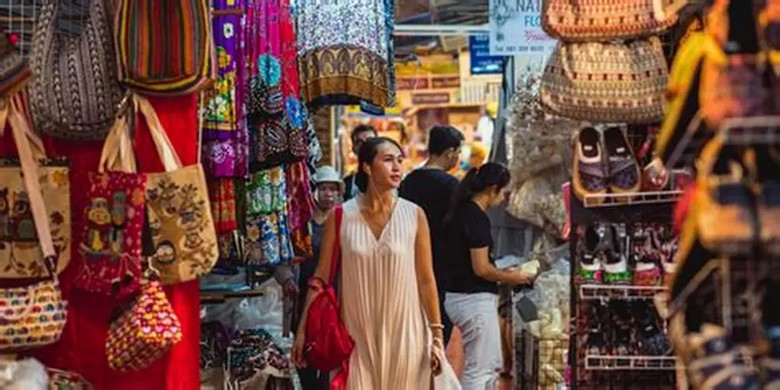 Du khách mỉm cười bước đi khỏi quầy hàng khi đang trả giá